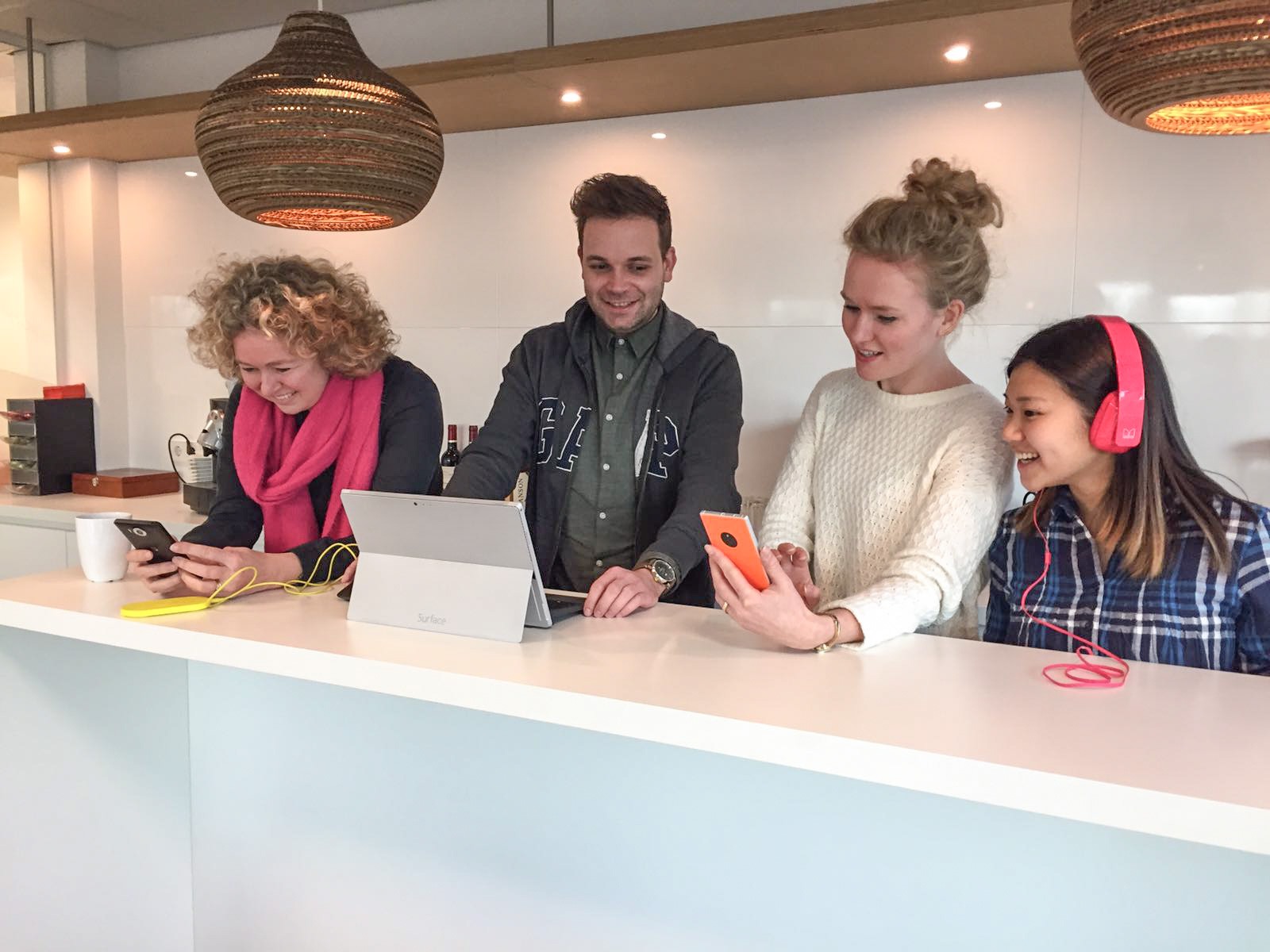 Collega's testen samen smartphones en een tablet